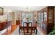 Formal dining room with a large wooden table, elegant hutch, and natural light streaming through the windows at 128 Holly Pl, Canton, GA 30115