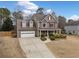 This lovely two-story home features well-maintained landscaping and a cozy front porch, with ample parking in the driveway at 128 Holly Pl, Canton, GA 30115