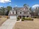 Charming two-story home with red shutters, a well-manicured lawn, and a driveway leading to an attached two-car garage at 128 Holly Pl, Canton, GA 30115