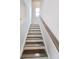 Bright stairway with hardwood steps and a wooden handrail leads to the next level of the home at 2412 Brown Dove Lot 71 Way, Grayson, GA 30017