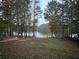 Backyard view with mature trees, leading to a lake, and a charming play area at 25 Clay Ct, Hiram, GA 30141