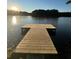 Scenic waterfront view with wooden dock on a peaceful lake surrounded by lush greenery at sunset at 25 Clay Ct, Hiram, GA 30141