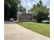 Charming two-story home with a well-manicured lawn and a brick-paved driveway, surrounded by mature trees and a view of the lake at 25 Clay Ct, Hiram, GA 30141