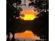 Beautiful lake view reflecting the vibrant colors of the sunset, framed by trees at 25 Clay Ct, Hiram, GA 30141