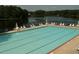 Community swimming pool with lounge chairs, set against a tranquil lake backdrop and lush trees at 25 Clay Ct, Hiram, GA 30141