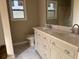 Bathroom with double sink vanity, light colored cabinets, and window at 25 Oak Crest Ct, Covington, GA 30016