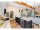 Bright kitchen featuring granite countertops, stainless steel appliances, island with sink, and wood beam ceiling at 81 Heritage Pointe Dr, Villa Rica, GA 30180