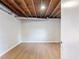 Unfinished basement area featuring wood floors, neutral paint, and a bare ceiling at 4239 Newcomb Rd, Decatur, GA 30034