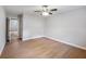 Neutral bedroom featuring light-colored wood floors, a ceiling fan, and a doorway to another room at 4239 Newcomb Rd, Decatur, GA 30034