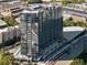 Aerial view of modern high-rise apartment building featuring a pool, parking, and surrounding greenery at 788 W Marietta Nw St # 913, Atlanta, GA 30318