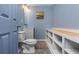 A blue half bathroom featuring a toilet, sink, and shelving unit at 1516 Ashford Club Ne Ct, Brookhaven, GA 30319