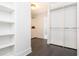 Bright closet with built-in shelves, hanging rods, and dark hardwood floors at 1516 Ashford Club Ne Ct, Brookhaven, GA 30319
