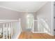 Bright stairway landing with white wood railing and gorgeous hardwood floors throughout at 1516 Ashford Club Ne Ct, Brookhaven, GA 30319