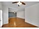 Open living room with wainscoting, hardwood floors, coffered ceiling and modern ceiling fan at 1520 Forest Brook Trl, Cumming, GA 30041