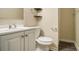 A clean bathroom featuring white cabinets, a sink, a toilet, and brushed nickel hardware at 2917 Toney Dr, Decatur, GA 30032
