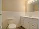 A white bathroom with a standard toilet, vanity, and a large mirror above the sink at 2917 Toney Dr, Decatur, GA 30032