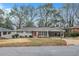 Charming single-story home featuring a well-maintained lawn, covered parking and a vibrant red front door at 2917 Toney Dr, Decatur, GA 30032