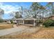 Ranch home with covered carport and sidewalk leading to the front, set against a backdrop of mature trees at 2917 Toney Dr, Decatur, GA 30032