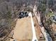 Drone shot of new construction home with long driveway, surrounded by woods, and large front lawn at 7760 E Cherokee Dr, Canton, GA 30115