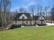 Charming two-story home with a welcoming front porch and lush green lawn, set against a wooded backdrop at 7760 E Cherokee Dr, Canton, GA 30115