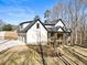 Backyard view featuring a two-story home with an elevated deck, and three-car garage at 7760 E Cherokee Dr, Canton, GA 30115