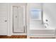 Bright bathroom with a combination tub and shower, wood flooring, and a privacy window at 804 White St, Villa Rica, GA 30180