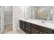 Bathroom featuring dual sinks, dark wood cabinetry, and a glass door shower at 4808 Albany Way, Atlanta, GA 30331