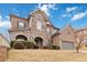 Charming two-story home featuring a stone and brick facade, arched entryway, and manicured landscaping at 4808 Albany Way, Atlanta, GA 30331