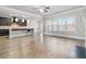 Open-concept living space combines a kitchen with bar seating with a living area, lots of light and wood-look floors at 4808 Albany Way, Atlanta, GA 30331