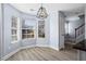 Bright dining area with large windows, modern light fixture, and wood-look flooring next to a staircase at 102 Johnson Ct, Decatur, GA 30030