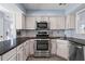 Updated kitchen boasts stainless steel appliances, white cabinets, dark countertops, and stylish backsplash at 102 Johnson Ct, Decatur, GA 30030
