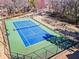 A tennis court surrounded by a fence and lots of trees sits on a green lot at 102 Johnson Ct, Decatur, GA 30030