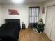 Neutral bedroom with a simple bed, hardwood floors, and storage bins by the window at 10936 Station Dr, Hampton, GA 30228