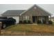 Charming single-story home with stone accents, a well-maintained yard, and an attached garage at 10936 Station Dr, Hampton, GA 30228