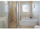 Bathroom with soaking tub, walk-in shower, tiled walls and decorative window at 2160 Berryhill Se Cir, Smyrna, GA 30082