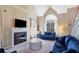 Cozy living room features a fireplace, plush blue seating, and abundant natural light from a large arched window at 2160 Berryhill Se Cir, Smyrna, GA 30082