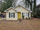 Charming single-story home with a yellow front door, black shutters, and a cozy landscaped front yard at 2921 8Th St, East Point, GA 30344
