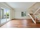 Bright living room with wood floors, large sliding doors to a balcony, and staircase at 587 Virginia Ne Ave # 315, Atlanta, GA 30306