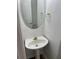 Cozy bathroom with a pedestal sink, decorative mirror, and gold fixtures at 12264 Crestwood Ct, Fayetteville, GA 30215