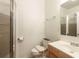 Bathroom featuring a shower with glass doors, toilet, vanity, and bright lighting at 550 Oak Ridge Dr, Oxford, GA 30054