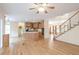 Open-concept living room features hardwood floors, a ceiling fan, stairs, and kitchen access at 550 Oak Ridge Dr, Oxford, GA 30054