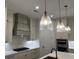 Modern kitchen with stainless steel appliances, stone countertops, custom vent hood and designer pendant lighting at 866 Lakemont Dr, Canton, GA 30114
