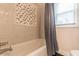 Inviting bathtub with tiled surround, complemented by natural light and a shower curtain for added privacy at 1472 North Nw Ave, Atlanta, GA 30318
