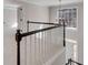 Hallway featuring a dark wood railing and banister and a view of a bright window and entryway at 2170 Azalea Dr, Roswell, GA 30075