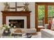 Cozy living room featuring a white-painted brick fireplace and french doors to the deck at 880 Cold Harbor Dr, Roswell, GA 30075