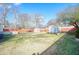 Large backyard with a shed, wood fence, car, and mature trees at 1724 Hill Ne St, Conyers, GA 30012