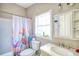 Cozy bathroom featuring a shower-tub with a floral curtain and marble sink at 1724 Hill Ne St, Conyers, GA 30012