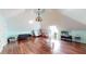 Large bonus room featuring wood floors, vaulted ceiling, modern lighting, a couch, and plenty of natural light at 1724 Hill Ne St, Conyers, GA 30012