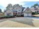 Charming two-story home with a well-manicured lawn, a red front door, and an attached two-car garage at 525 Tilbury Dr, Suwanee, GA 30024