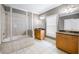 Spacious bathroom featuring a large tub-shower combo with glass doors, wooden cabinets, and white tile flooring at 1363 Summer Lane Se Dr, Atlanta, GA 30316